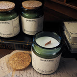 Candle jars with labels on a surface with books and papers