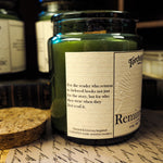 Candle jar labeled 'Reminiscence' on a surface with other similar jars in the background.