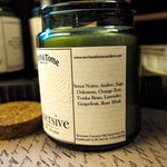 Candle jar with a label on a textured surface