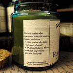 Candle jar featuring label with dedication to readers on the side sitting on top of a wood desk
