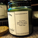Green candle jar with a label on a textured surface