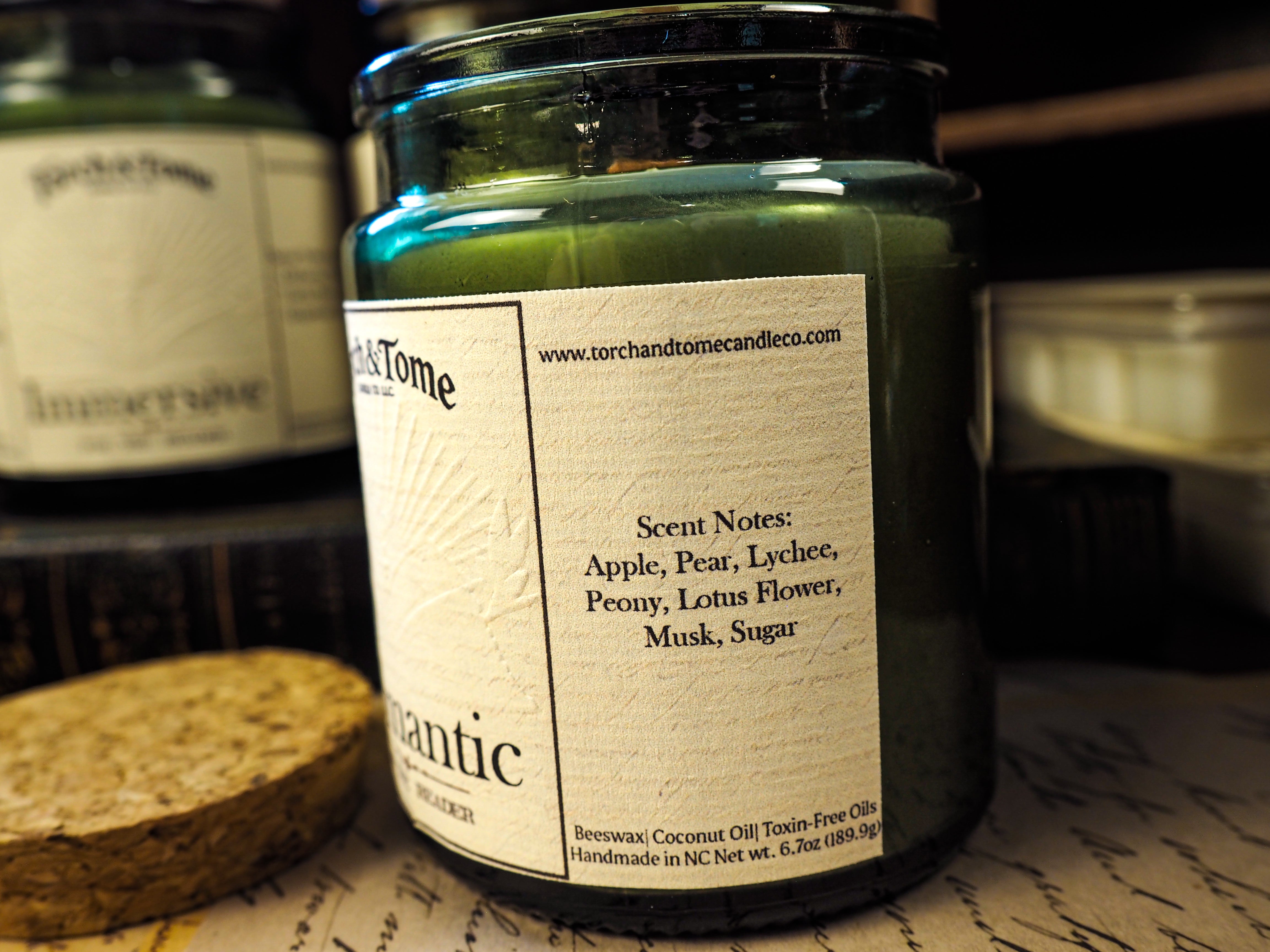 Green candle jar with a label on a textured surface