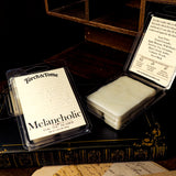 Torch & Tome Melancholic wax melts packaging on a dark surface with an open container.