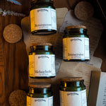 Five jars labeled 'Reminiscent', 'Immersive', 'Melancholic', 'Romantic', and 'Academic' on a wooden surface with decorative elements.