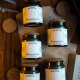Five jars labeled 'Reminiscent', 'Immersive', 'Melancholic', 'Romantic', and 'Academic' on a wooden surface with decorative elements.