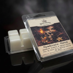 Syndicate Siren wax melt package with label depicting a female, black roses, vanilla flower, whiskey glass, and a skull on a dark smoky background. A second wax melt clamshell is propped upside down showing the ivory beeswax