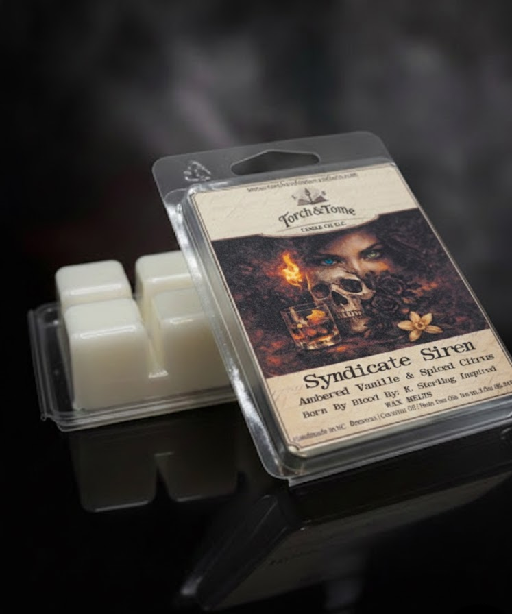Syndicate Siren wax melt package with label depicting a female, black roses, vanilla flower, whiskey glass, and a skull on a dark smoky background. A second wax melt clamshell is propped upside down showing the ivory beeswax