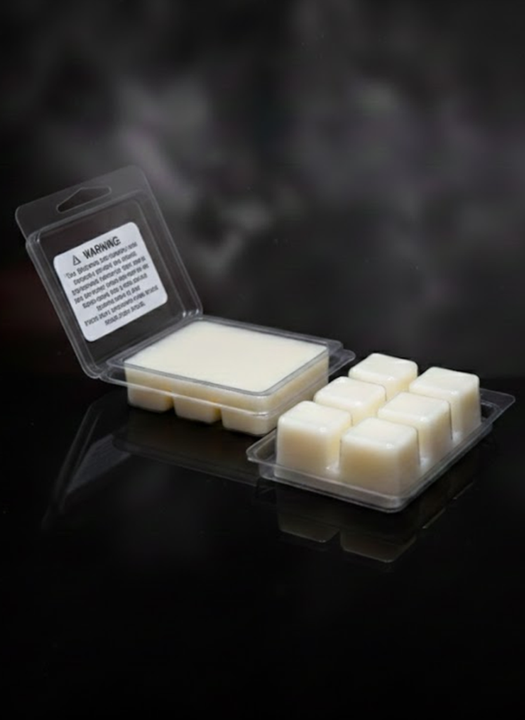 Packaged wax melts with a warning label on a dark smoky background showing the ivory beeswax.