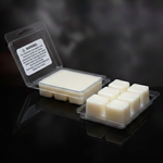 Packaged wax melts with a warning label on a dark smoky background showing the ivory beeswax.